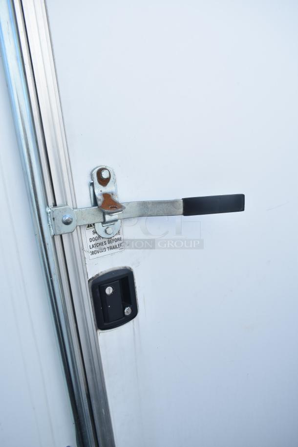 Close-up of the handle and lock on a 2021 Diamond Cargo 8.5' x 24' cold food and beverage fulfillment trailer door.