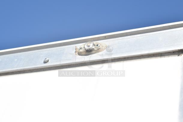 Close-up of the top edge of a 2021 Diamond Cargo 8.5' x 24' trailer, highlighting metal construction and a light fixture.