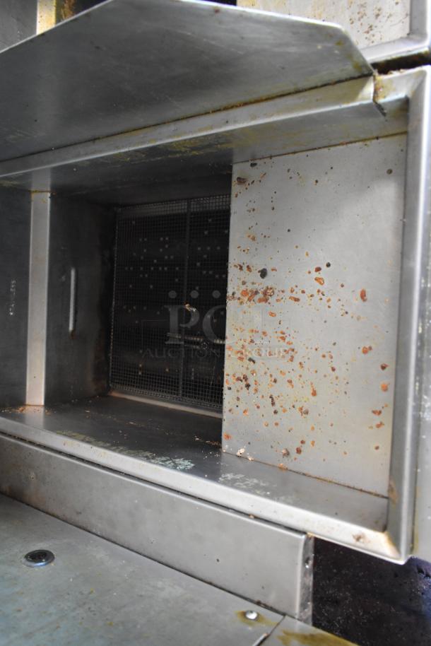 2012 Quality Cargo food trailer interior, showing stainless steel surfaces with some rust and grime. Dual fryer and pizza prep configuration.