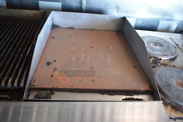 2012 Quality Cargo food trailer grill and cooktop, showing signs of use, equipped for dual fryer and pizza prep.