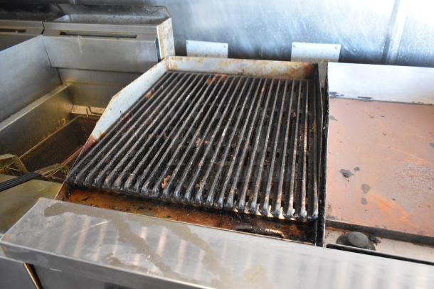 2012 Quality Cargo food trailer grill and fryer setup, used condition with visible residue, for sale.