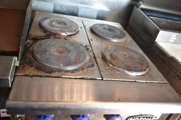 2012 Quality Cargo food trailer stove showing four worn burners, stainless steel surface, part of dual fryer and pizza prep setup.