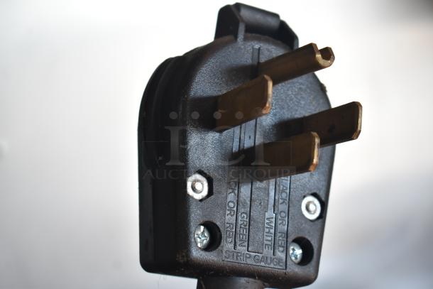 Close-up image of a black electrical plug with visible screws and labeling indicating wire colors: black, red, green, and white.