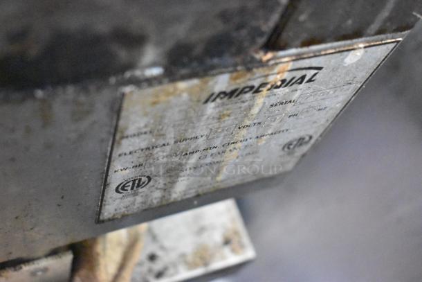 Rusty metal label on Quality Cargo food trailer, blurred details, indicating model and serial number information.