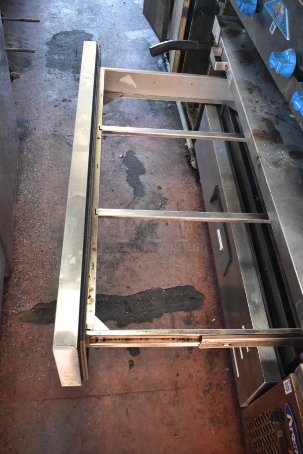 2012 Quality Cargo food trailer interior, focusing on kitchen equipment including metal framework and control knobs.