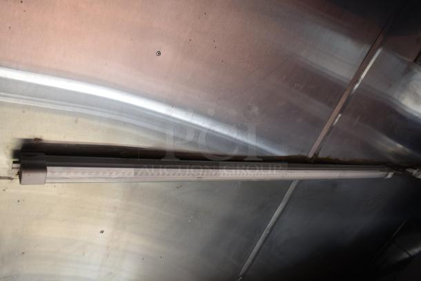 Interior view of 2012 Quality Cargo Food Trailer, showcasing metal ceiling and fluorescent light fixture.