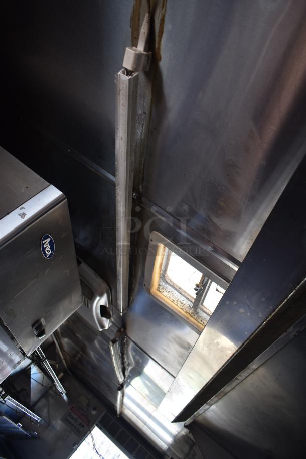 2012 Quality Cargo food trailer interior, featuring stainless steel walls, lighting fixtures, and a window for ventilation.