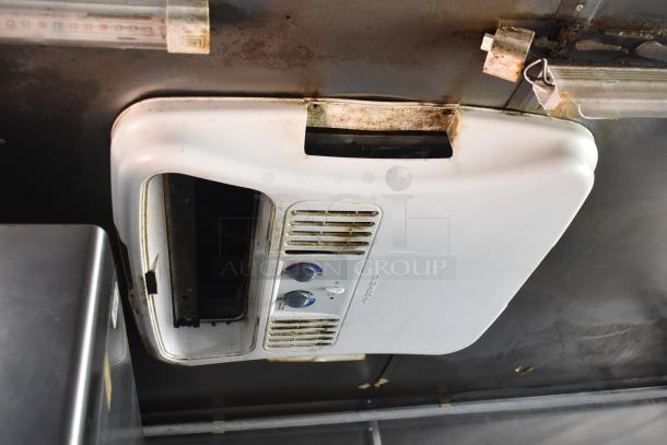 Close-up of a vintage white kitchen exhaust fan in a 2012 Quality Cargo food trailer, showing controls and signs of use.