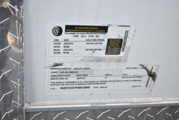 2012 Quality Cargo food trailer ID tag with VIN 50ZZ1E427KN012840, GVWR 9,990 lbs, tire details, and manufacturing info.