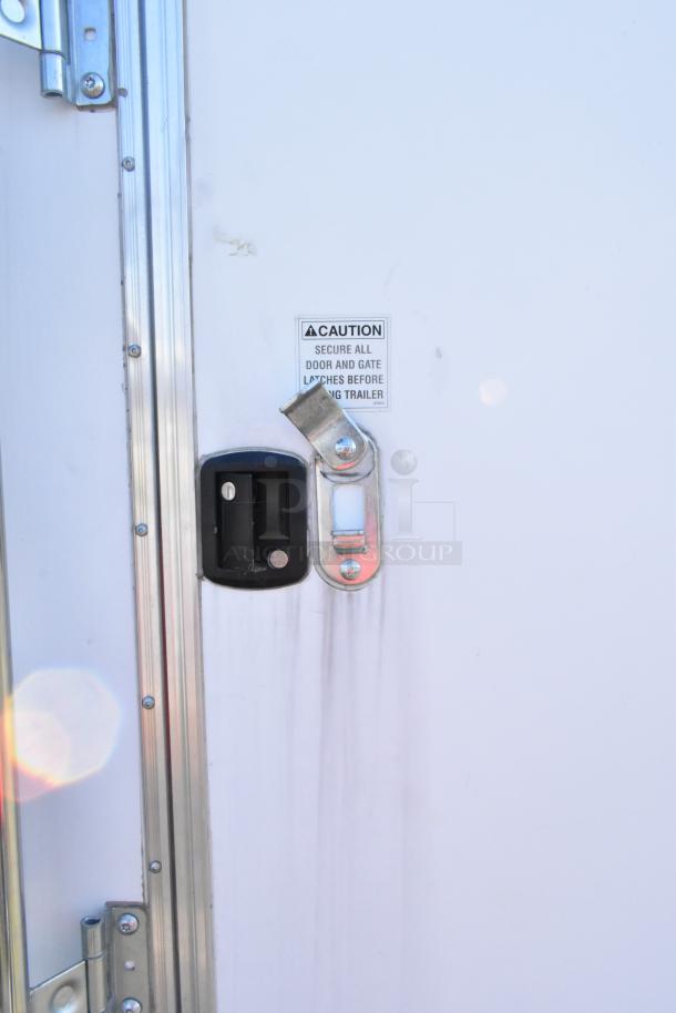 Diamond Cargo 8.5' x 24' food trailer door with secure latch and caution label visible. Model year 2021.