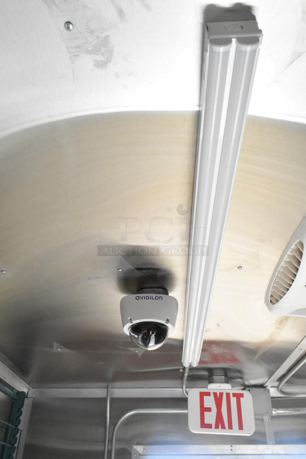 Interior of 2021 Diamond Cargo 8.5' x 24' food trailer with Avigilon camera, overhead lighting, and exit sign.