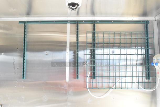 2021 Diamond Cargo food trailer interior with mounting brackets, grid shelf, and wiring. Clean stainless steel finish.