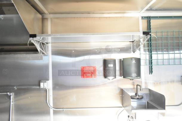 2021 Diamond Cargo 8.5' x 24' food trailer interior with grease hood, hand sink, and dispensers. Includes air conditioning system.