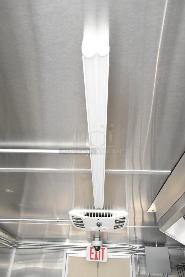 2021 Diamond Cargo 8.5' x 24' food trailer interior, featuring air conditioning system, overhead lighting, and exit sign.