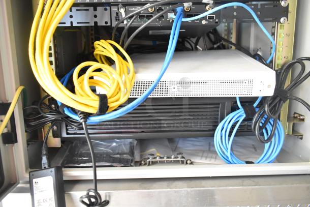 A tangle of yellow and blue cables inside an electronic rack with networking equipment.