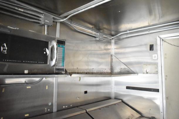2020 Diamond Cargo 8.5' x 24' mobile kitchen trailer interior, featuring a commercial microwave oven and stainless steel surfaces.