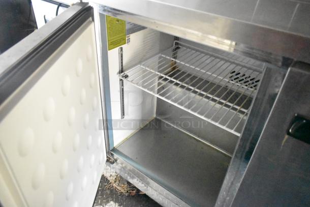 Open refrigerator inside the 2020 Diamond Cargo mobile kitchen trailer with wire shelving and a clean interior.