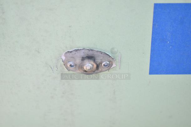 Close-up of a light fixture on a 2021 Diamond Cargo 8.5' x 24' trailer. Minor wear visible around screws.