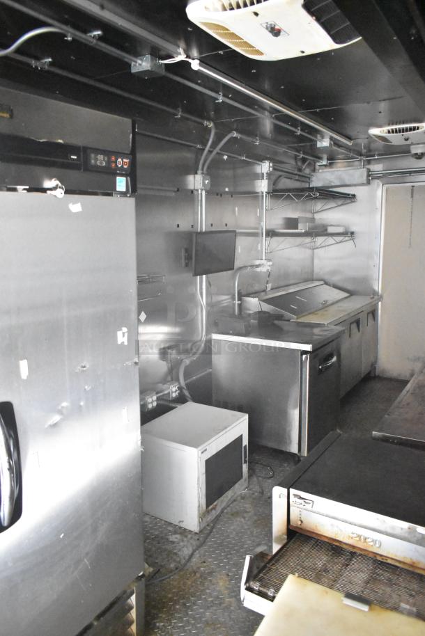 2021 Diamond Cargo 8.5' x 24' food trailer interior, featuring stainless steel appliances, shelves, and cooling equipment.