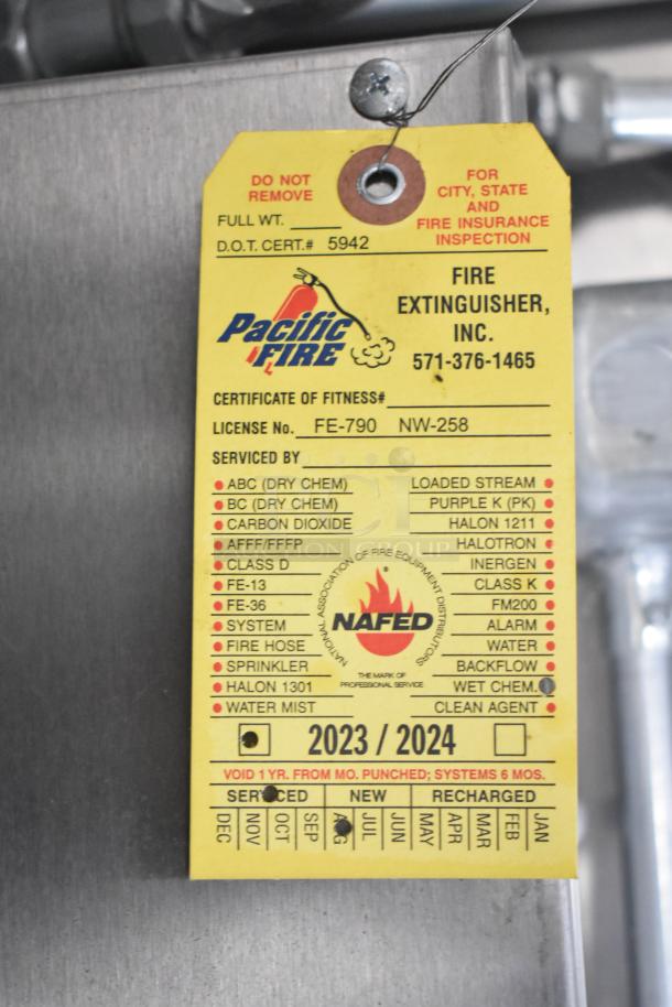 Yellow fire extinguisher inspection tag on a 2021 Diamond Cargo 8.5' x 24' trailer. Certified and serviced for 2023/2024.