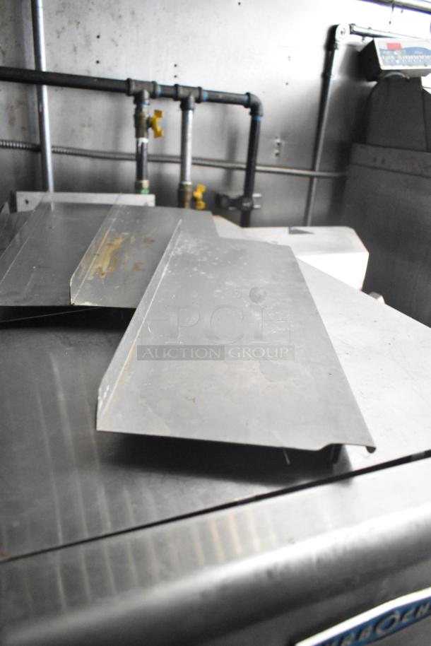 Interior view of the 2021 Diamond Cargo 8.5' x 24' cold food trailer, showing metal work surfaces and pipe fixtures.