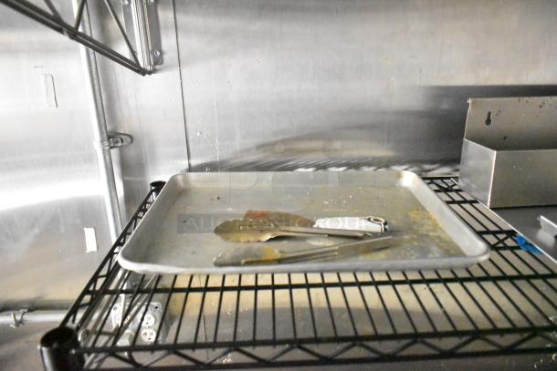 Interior view of a 2021 Diamond Cargo cold food trailer, featuring a metal tray on a wire rack shelf.