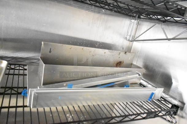 2021 Diamond Cargo 8.5' x 24' cold food trailer interior with metal shelving and parts, showing wear and use.