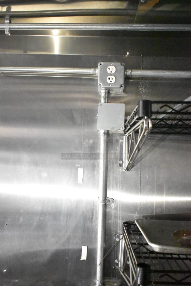 2021 Diamond Cargo 8.5' x 24' trailer interior, showing metal shelves, electrical outlets, and conduit, emphasizing utility and condition.