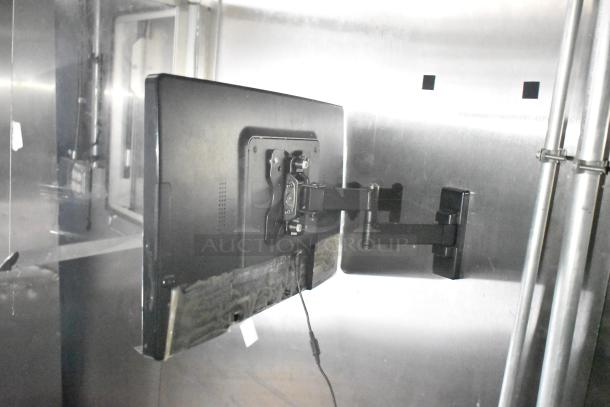 Interior of a 2021 Diamond Cargo cold food trailer with a wall-mounted monitor and support bracket, showcasing modern equipment.