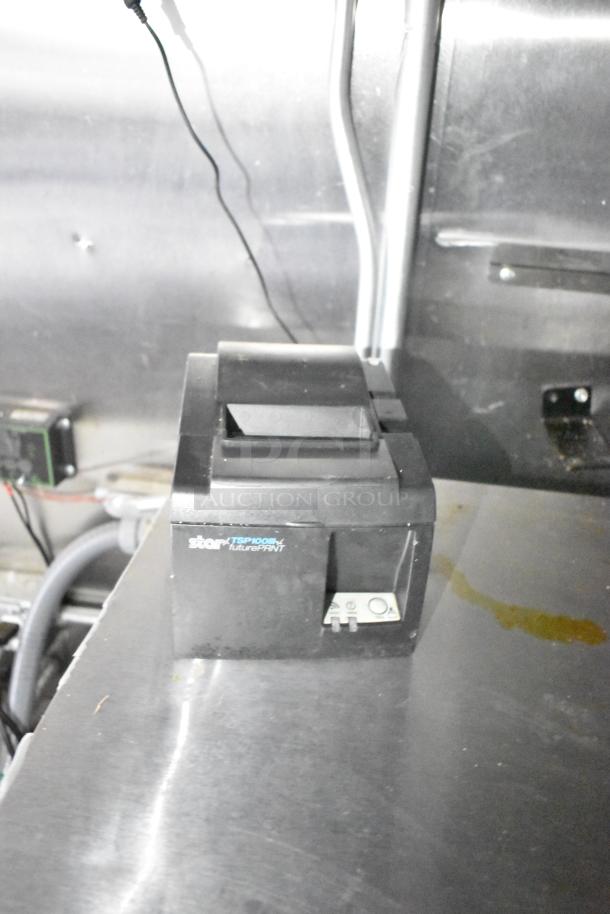 Star TSP100 thermal printer on a metal surface inside the trailer. Printer appears to be in used condition.