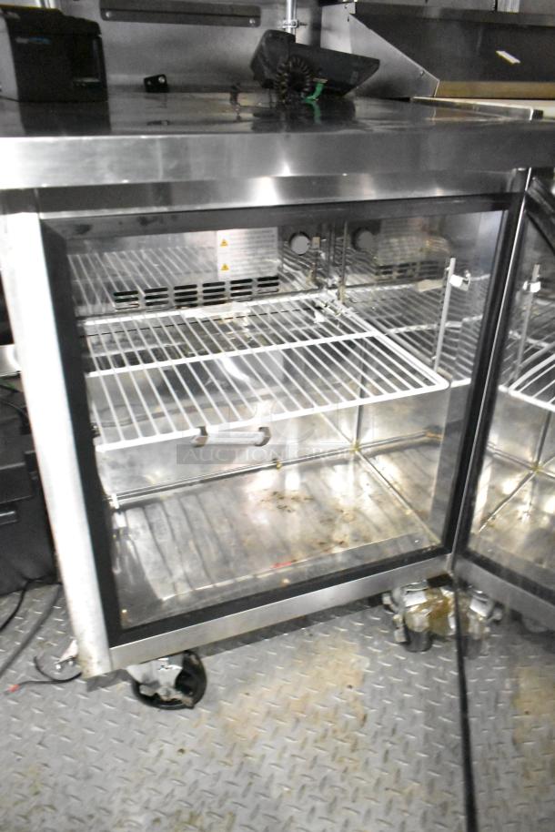 2021 Diamond Cargo 8.5' x 24' food trailer interior view, showcasing metal shelves and equipment inside.