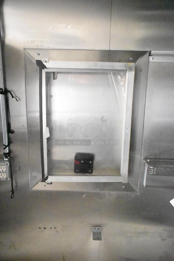 Interior view of 2021 Diamond Cargo 8.5' x 24' trailer showing metal walls, a small window, and electrical outlet.