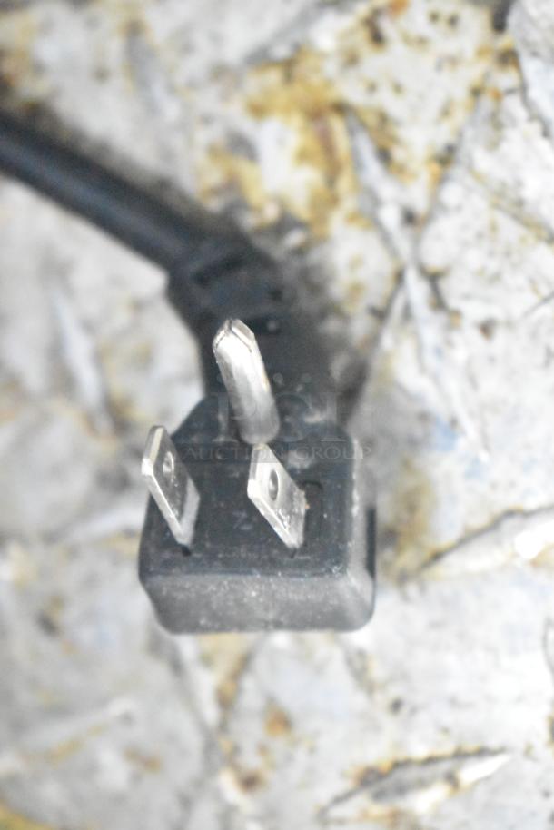 Close-up of an electrical plug on a textured surface, related to the 2021 Diamond Cargo 8.5' x 24' trailer.
