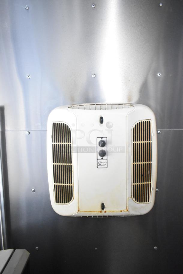 Diamond Cargo trailer interior, showing a Coleman-Mach AC unit. Visible wear, white with vents, affixed to metal panel.