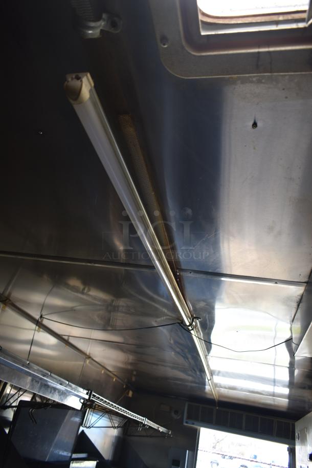 2019 Quality Cargo 24ft food trailer interior, showing stainless steel surfaces and overhead lighting. Restoration needed.