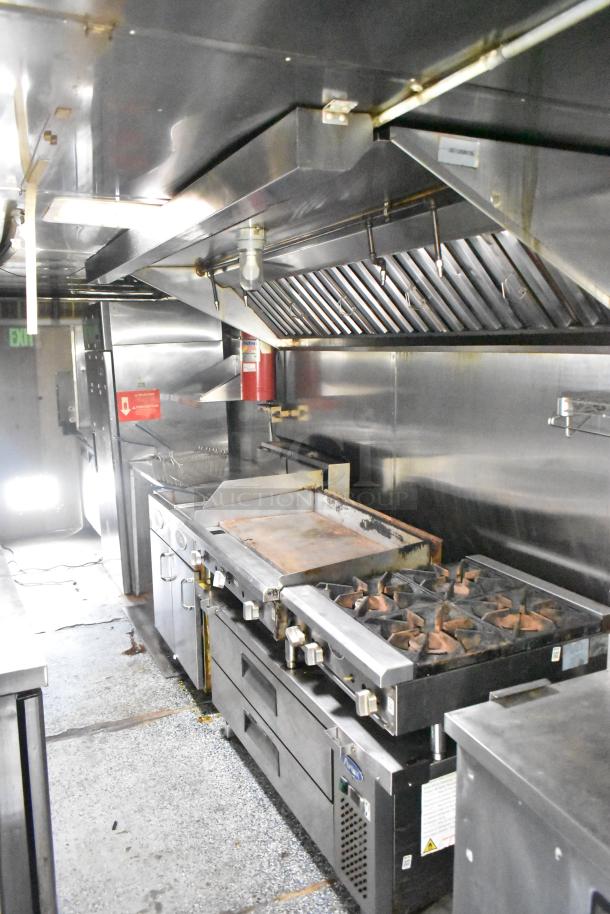 2019 Quality Cargo 24ft food trailer interior, featuring a grease hood, Royal Range griddle, gas fryer, and refrigeration units.