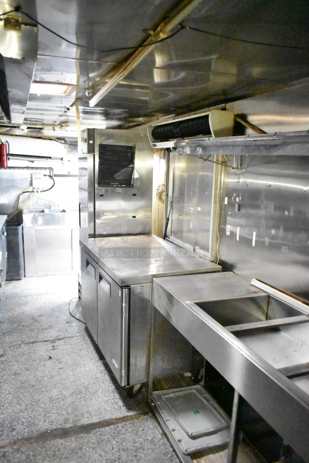 2019 Quality Cargo 24ft food trailer interior with grease hood, Royal Range griddle, gas fryer, and four-unit refrigeration. VIN 50ZZ1E426KN012862.