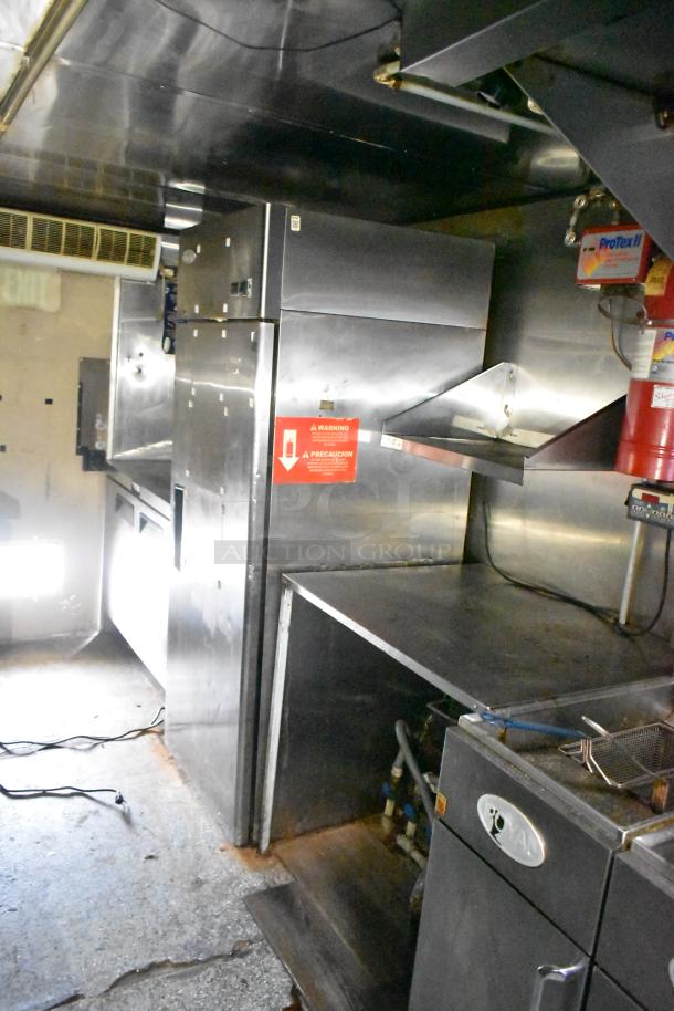 2019 Quality Cargo 24ft food trailer interior with grease hood system, Royal Range griddle, Royal gas fryer, refrigeration units visible.