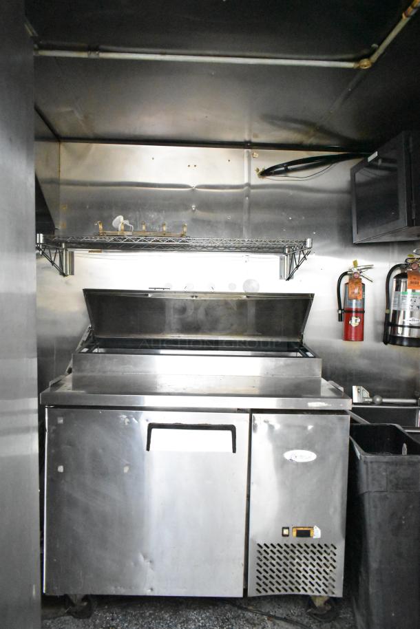 2019 Quality Cargo 24ft food trailer interior with stainless steel Royal Range griddle, visible storage, and fire extinguishers.