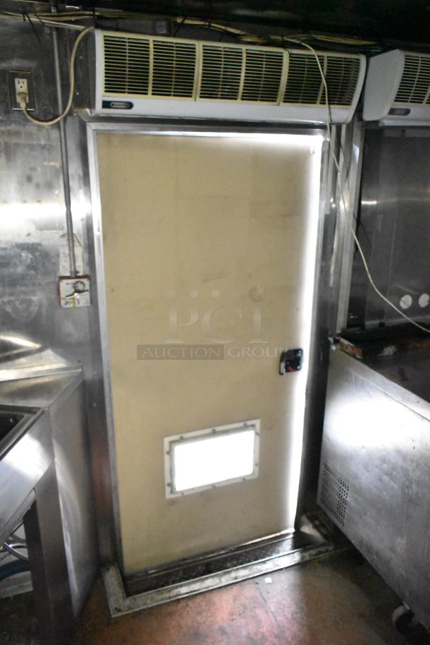 Interior view of 2019 Quality Cargo 24' food trailer with door, stainless steel surfaces, and visible wiring, highlighting commercial-grade setup.