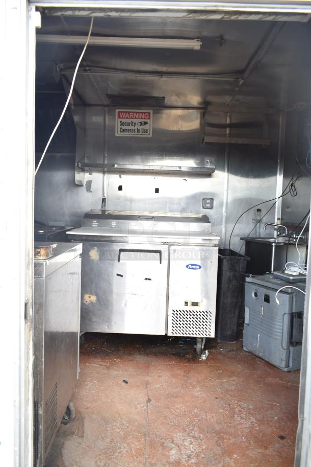 2019 Quality Cargo 24' food trailer interior with kitchen equipment. Features grease hood, fryer, grill, and Blodgett oven.