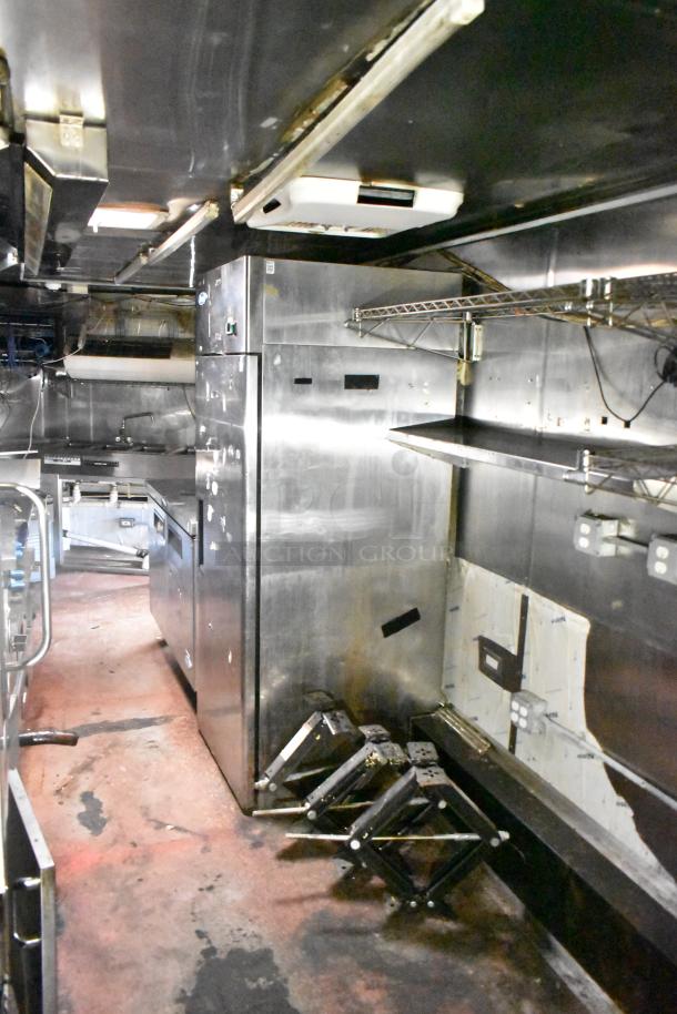 2019 Quality Cargo 24' food trailer interior with stainless steel equipment, including a grease hood, fryer, grill, and oven.