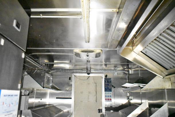 2020 Diamond Cargo 24' commercial kitchen trailer interior with grease hood, Pitco fryer, Wells griddle, and Arctic Air refrigeration.