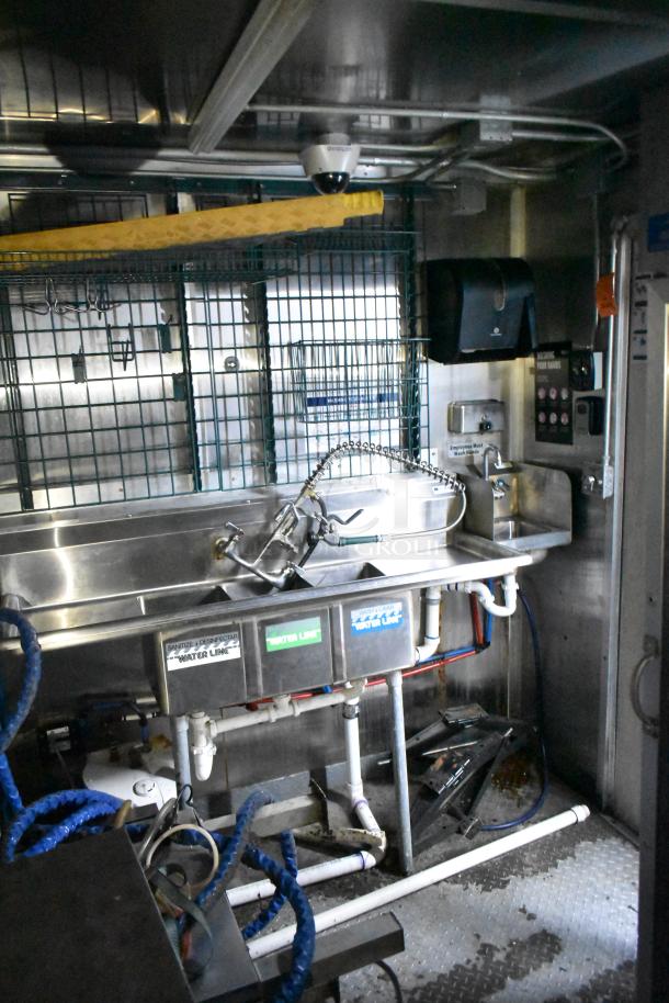 2020 Diamond Cargo 24' kitchen trailer interior, featuring a stainless steel sink with labeled water lines and industrial plumbing.