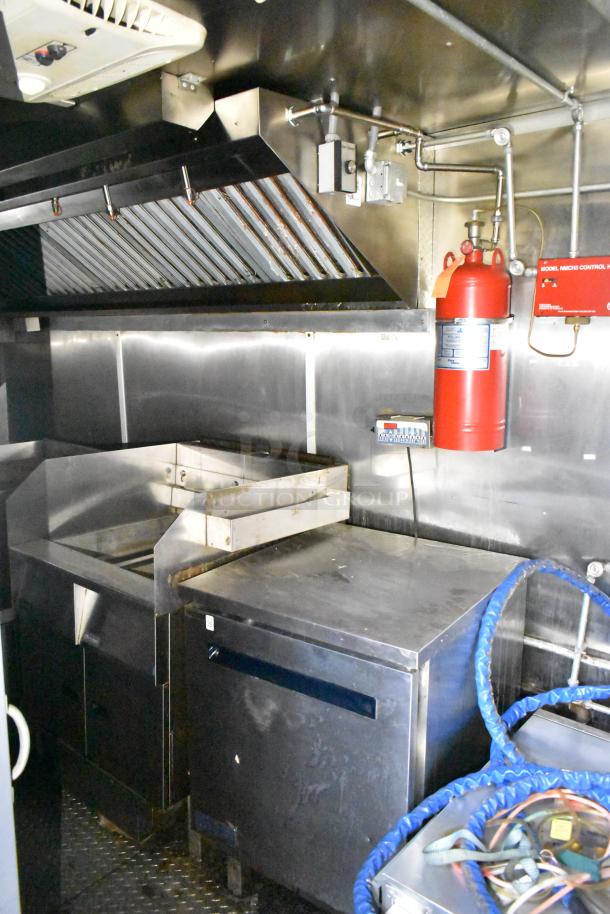 2020 Diamond Cargo 24' kitchen trailer interior with grease hood, Pitco fryer, Wells dual griddle, and Arctic Air fridge suite.