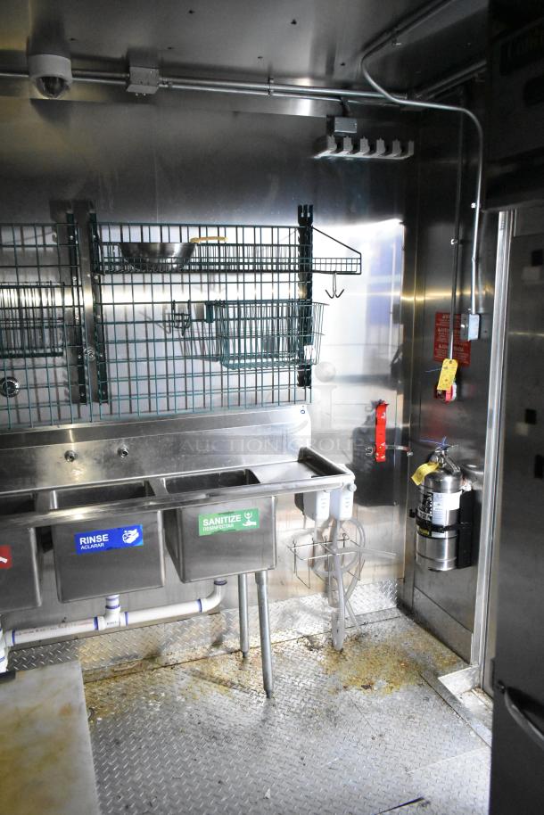 2021 Diamond Cargo 8.5x24 mobile kitchen interior with stainless steel triple sink, Econ-Air hood, and fire extinguisher.