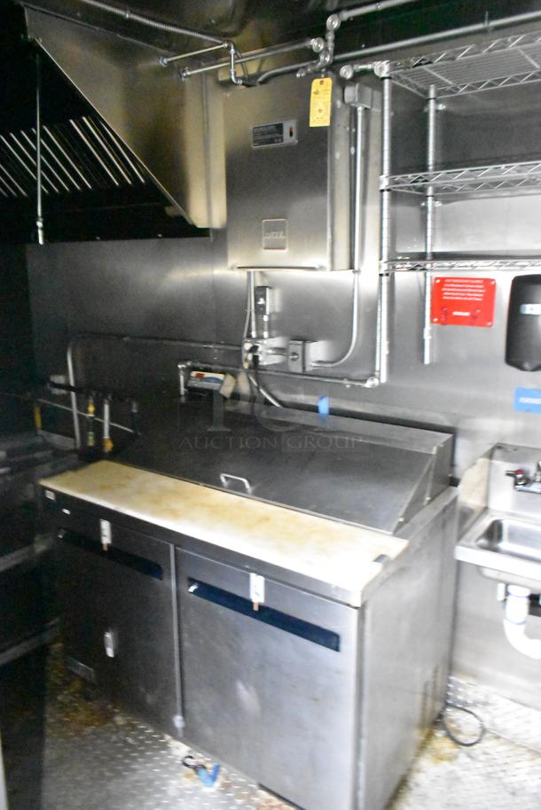 2021 Diamond Cargo 8.5x24 mobile kitchen interior with Econ-Air hood and stainless steel refrigeration.
