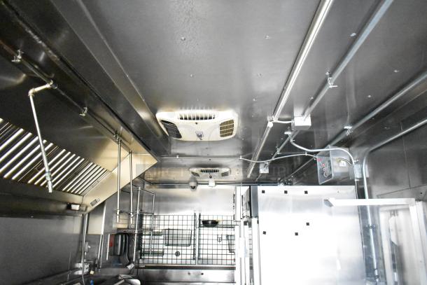 Interior of 2021 Diamond Cargo 8.5x24 mobile kitchen trailer featuring Econ-Air hood, TurboChef ovens, and refrigeration units.