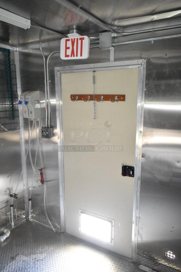 LIKE NEW! 2021 Diamond Cargo 24ft x 8.5ft commercial kitchen trailer interior, featuring Paragon hood, Ansul fire suppression, metal walls, and exit sign. Ready for custom setup.