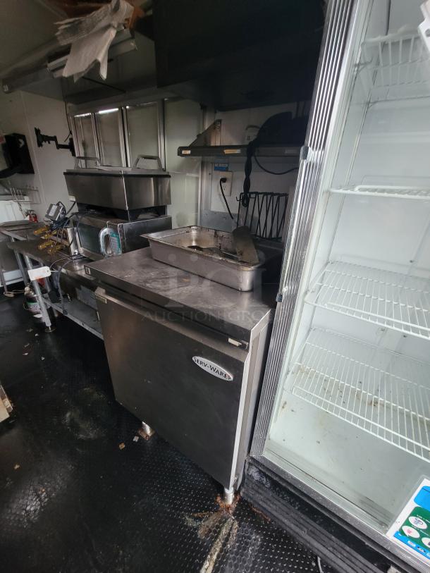 2020 Rock Solid 16' mobile kitchen interior with Serv-Ware freezer, Dukers merchandiser, and stainless prep surfaces.